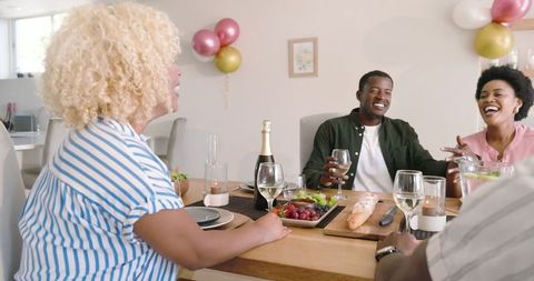 Friends Laughing Together Over Festive Home Dining
