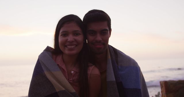 Couple Wrapped in Blanket Smiling Near Beach Sunset - Download Free Stock Images Pikwizard.com