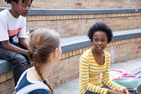 Teenage Friends Socializing in School Amphitheater