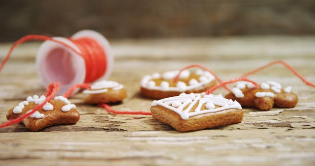 Homemade gingerbread cookies with white icing are artfully tied with a red string, with copy space - Download Free Stock Photos Pikwizard.com