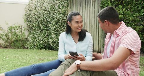 Happy young couple taking selfie outdoors in sunny garden