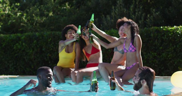 Diverse group of female friends eating watermelon sitting at the poolside drinking beer. hanging out and relaxing outdoors in summer.