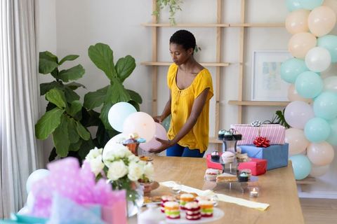 Woman arranging balloons for elegant indoor celebration