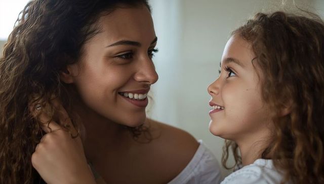 Mother and daughter sharing tender smile and eye contact in soft natural light