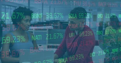 Coworkers Collaborating Over Laptop While Analyzing Stock Market Data Overlay in Office