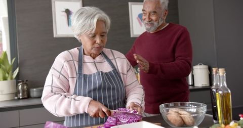 Senior Couple Feeding Together in a Cozy Kitchen Setting