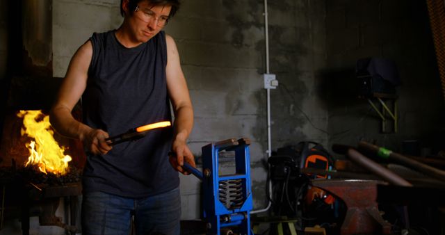 Blacksmith Forging Metal in Workshop with Glowing Orange Metal - Download Free Stock Images Pikwizard.com