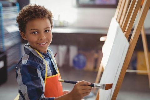Young Boy Painting on Easel in Art Studio