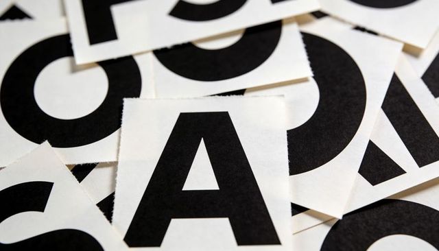 Showing bold letter a on torn paper squares closeup creating high-contrast typography