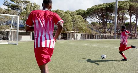 Soccer Players Practicing Kicking Techniques on Field