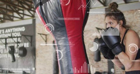Female boxer training with heavy bag and performance data overlay, guarding intently