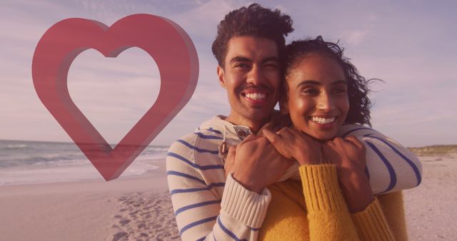 Image of red heart over couple in love embracing on beach. Valentine's day, love and romance concept digitally generated image.