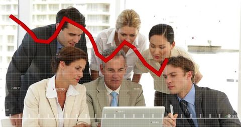Executive team analyzing downward market trend on laptop during boardroom strategy session