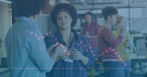 Diverse team collaborating in open-plan office with data overlay