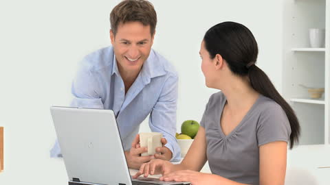 Couple Chatting Over Coffee and Laptop in Modern Kitchen