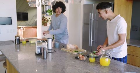 Friends Cooking Breakfast Together in Modern Kitchen