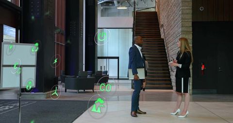 Executives networking in modern office lobby with augmented reality overlays and laptop