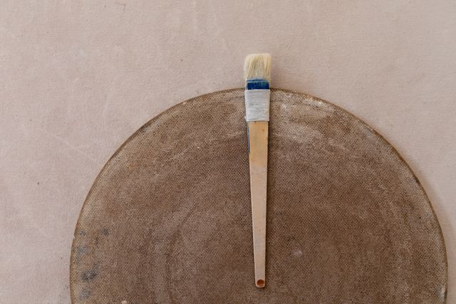 A brush lying on a pottery wheel on a table. small creative business at pottery studio.