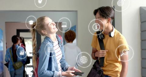 Teen students laughing in school corridor using mobile devices with digital learning icons