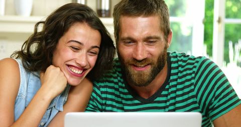 Smiling couple enjoying online content at home