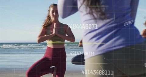 Women Practicing Yoga in Tree Pose on Beach: Embracing Balance and Serenity