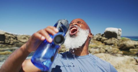 Elderly Athlete Refreshing by Seaside During Workout