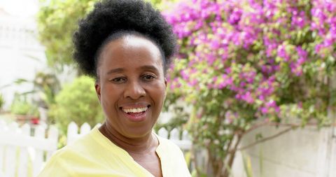 Senior African American Woman Smiling in Blooming Garden