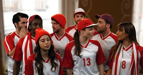 Enthusiastic Group of Sports Fans in Red and White Jerseys Cheering