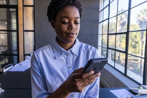 Professional Woman Engaged with Smartphone in Office Environment