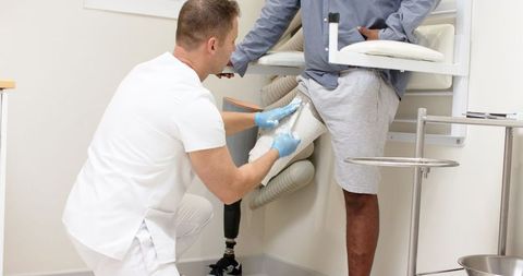 Clinician Fitting Prosthetic Socket on Patient in Medical Clinic