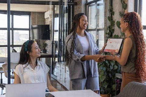 Female Professionals Celebrating Certification in Office Environment