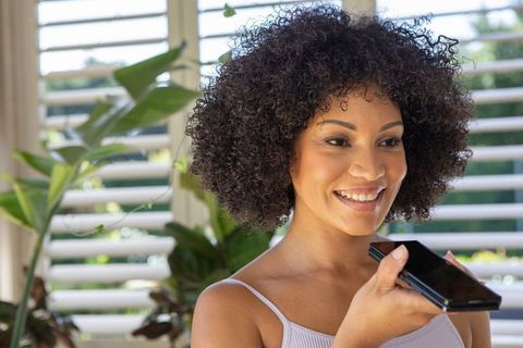 Smiling Woman Using Smartphone in Bright Home Interior