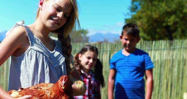 Happy children holding chicken on sunny farm - Download Free Stock Images Pikwizard.com