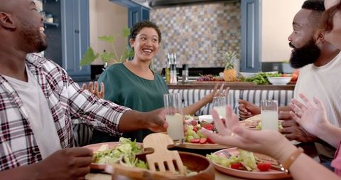 Joyful Friends Gathering Around Table Sharing Meal Living Room