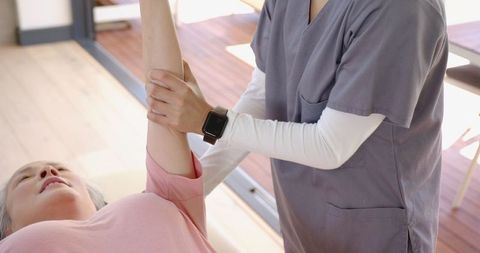 Senior woman receiving physical therapy at home with professional care