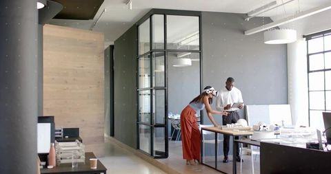 Colleagues Collaborating with VR and Tablet in Modern Office