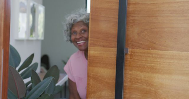 Portrait of happy senior african american woman opening door at retirement home. healthy, active retirement and body inclusivity.