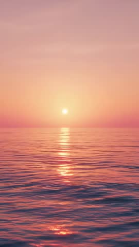 Vertical video showing rising sun casting golden reflection across calm ocean at serene dawn