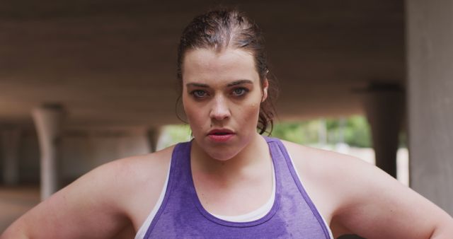 Portrait of determined plus size caucasian woman fitness training in city. City living, fitness and modern urban lifestyle.