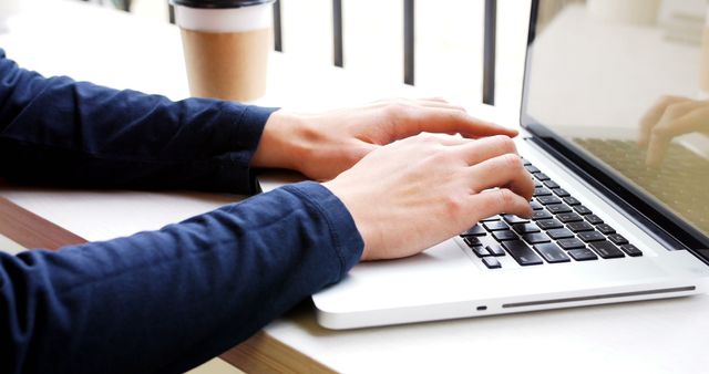 Person typing on laptop with coffee cup in background - Download Free Stock Images Pikwizard.com