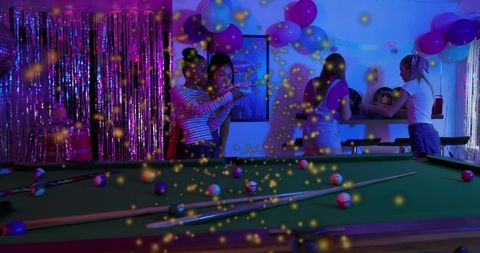 Neon billiards lounge party with friends playing pool under moody colorful lights