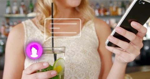 Checking smartphone while holding cocktail at bar with chat overlay and nightlife vibe