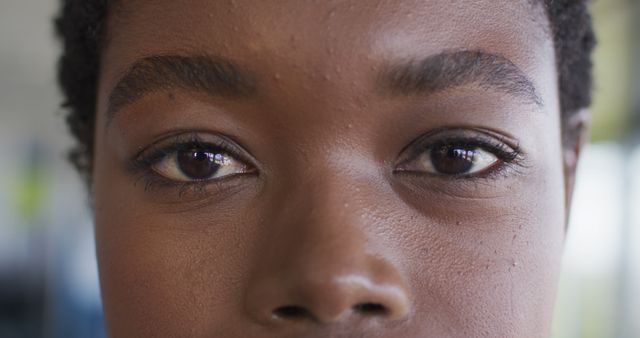 This image shows a close-up of a young person's eyes, highlighting detailed skin and natural beauty. The expression is calm and serene, suggesting themes of contemplation, focus, or tranquility. It can be used in articles about inner thoughts, beauty routines, skincare, mental health, self-reflection, or promotional materials for eye care products.