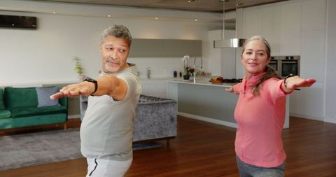 Active Senior Couple Performing Stretches at Home for Wellness