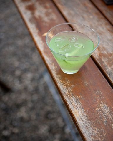 Refreshing lime drink in a glass with ice on wooden table