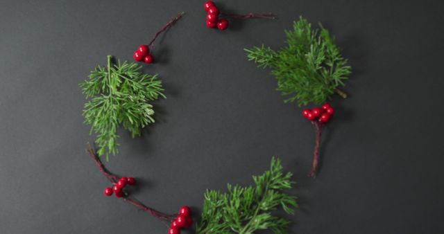 Evergreen branches and red berries arranged in a circular wreath form. This can be used for holiday-themed projects, greeting cards, invitations, or festive promotional materials.