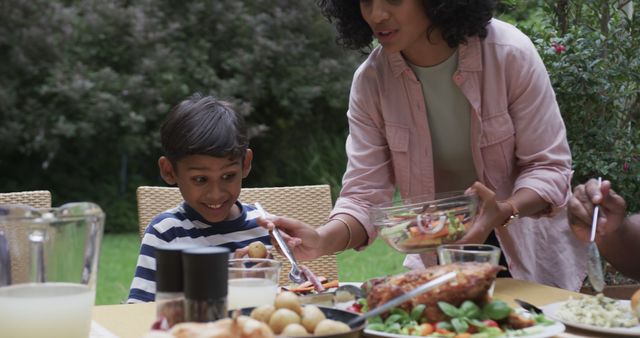 Mother Serving Salad to Happy Son at Outdoor Family Dinner - Download Free Stock Images Pikwizard.com