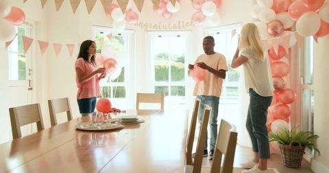 Friends preparing decorations for celebratory party at home