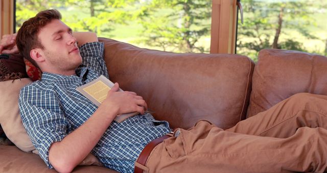 Young Man Relaxing on Couch with Book in Hand - Download Free Stock Images Pikwizard.com