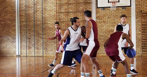 Energetic Young Athletes Competing in Indoor Basketball Game